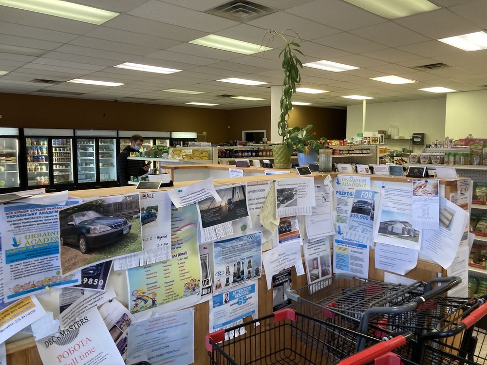 Inside Ukrainian Village Food & Deli, with the community noticeboard by the counter